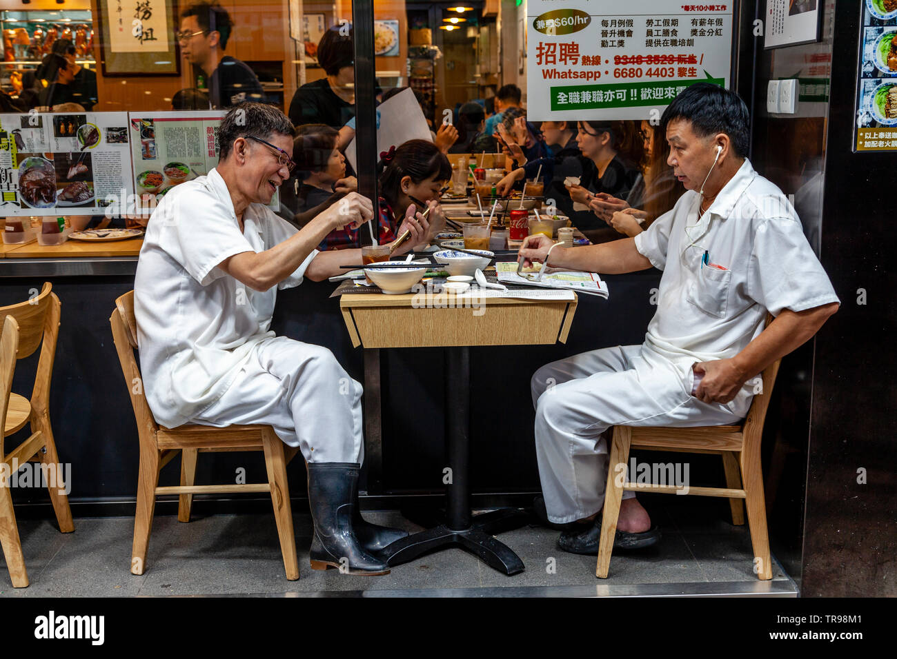 Due Hong Kong lavoratori godendo il pranzo, Hong Kong, Cina Foto Stock