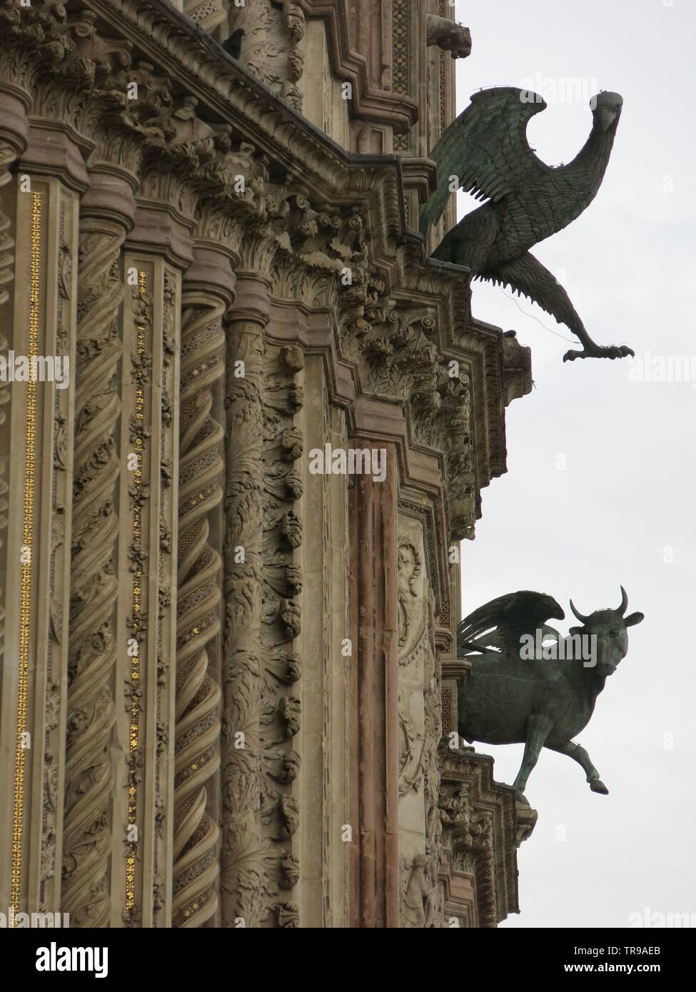 Vista ravvicinata di intricati colonne e due sculture sulla facciata anteriore del Duomo di Orvieto Foto Stock