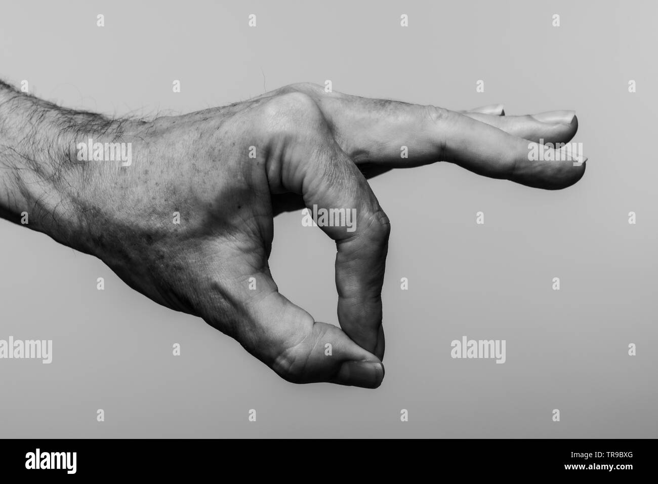 In prossimità di una mano mans rendendo un simbolo OK, in bianco e nero. Foto Stock