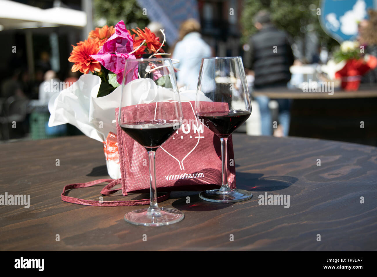 Due bicchieri di vino al vino rosso con fiori sul tavolo durante il tradizionale vino e cibo mostra evento VINUM ALBA Italia Europa Foto Stock