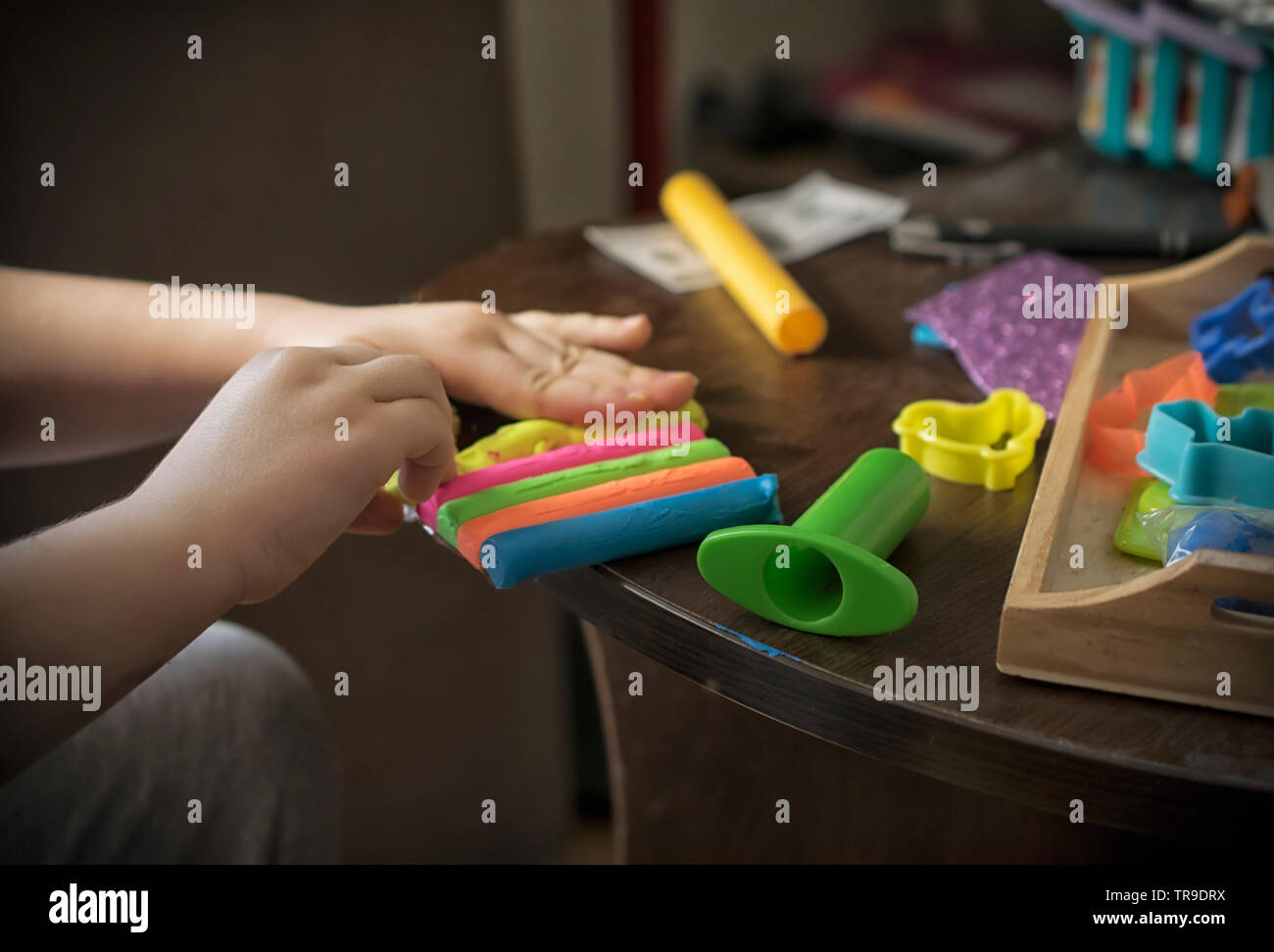 Un close-up di un bambino con le mani in mano durante il gioco con la plastilina Foto Stock