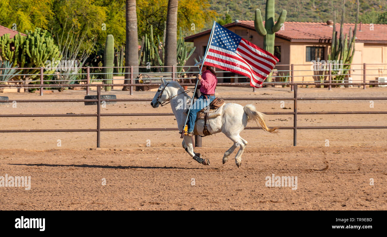 Rodeo settimanale a White Stallion Ranch, un dude ranch al di fuori di Tucson, AZ. Portando la bandiera americana, sempre l'inizio del rodeo. Foto Stock