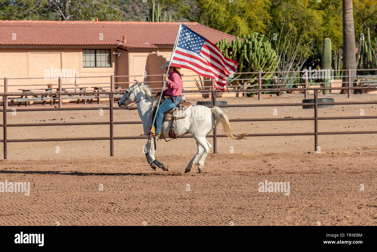 Rodeo settimanale a White Stallion Ranch, un dude ranch al di fuori di Tucson, AZ. Portando la bandiera americana, sempre l'inizio del rodeo. Foto Stock