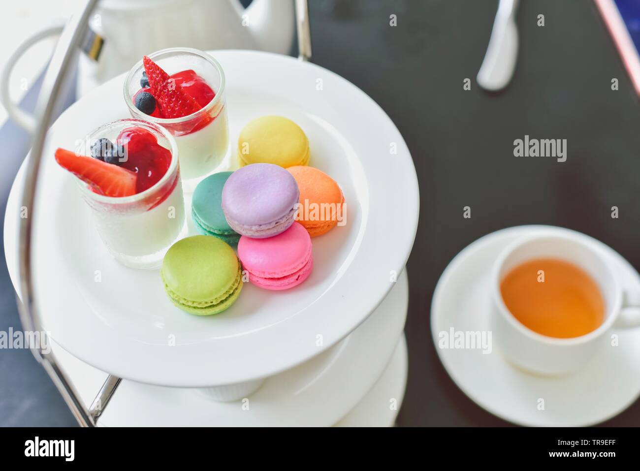 Un tradizionale tè inglese pomeridiano impostato con colorati Macarons e dessert Foto Stock