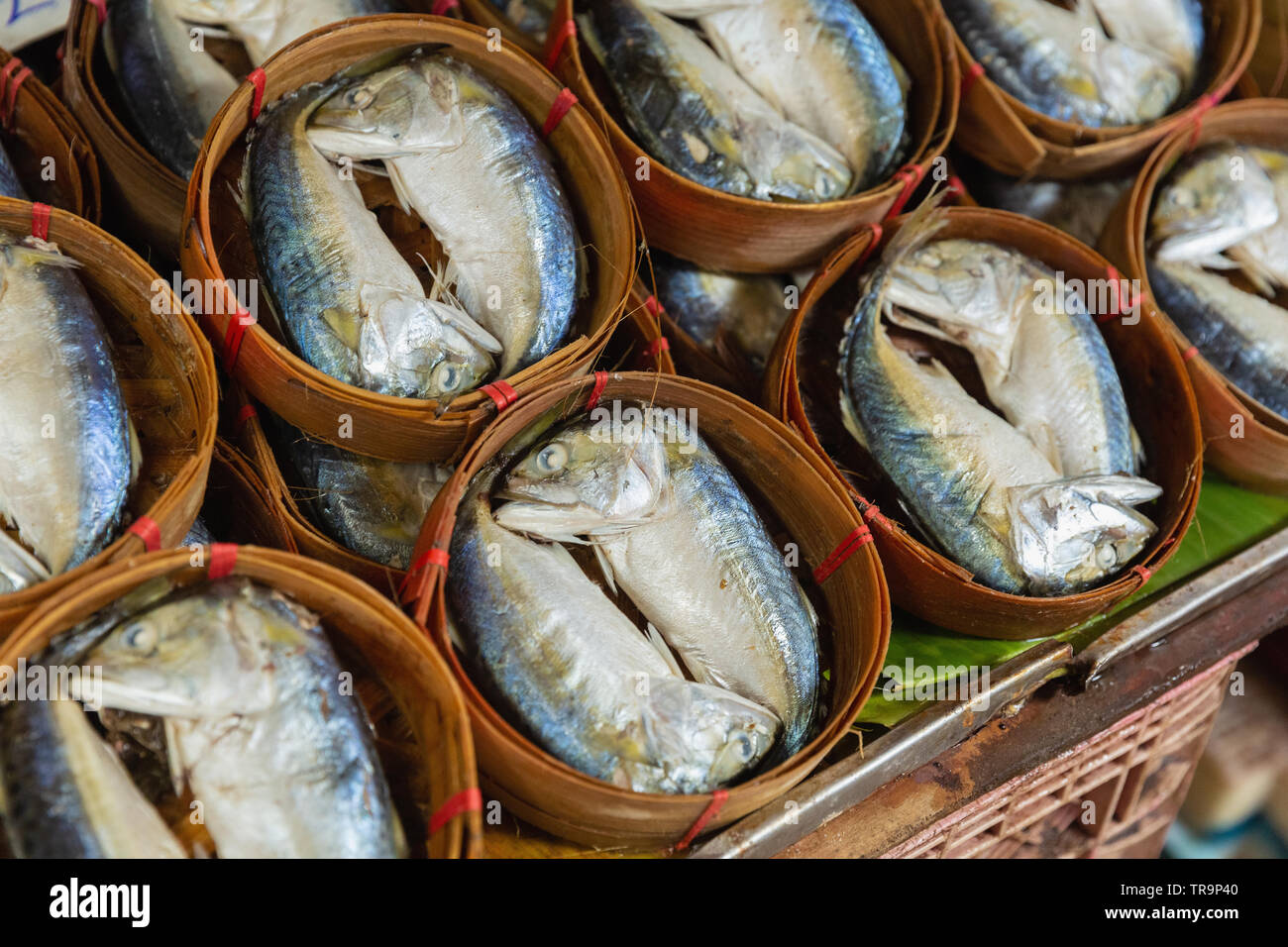 Cesto in legno di pesce per la vendita presso il Maeklong mercato ferroviario, Bangkok, Thailandia Foto Stock