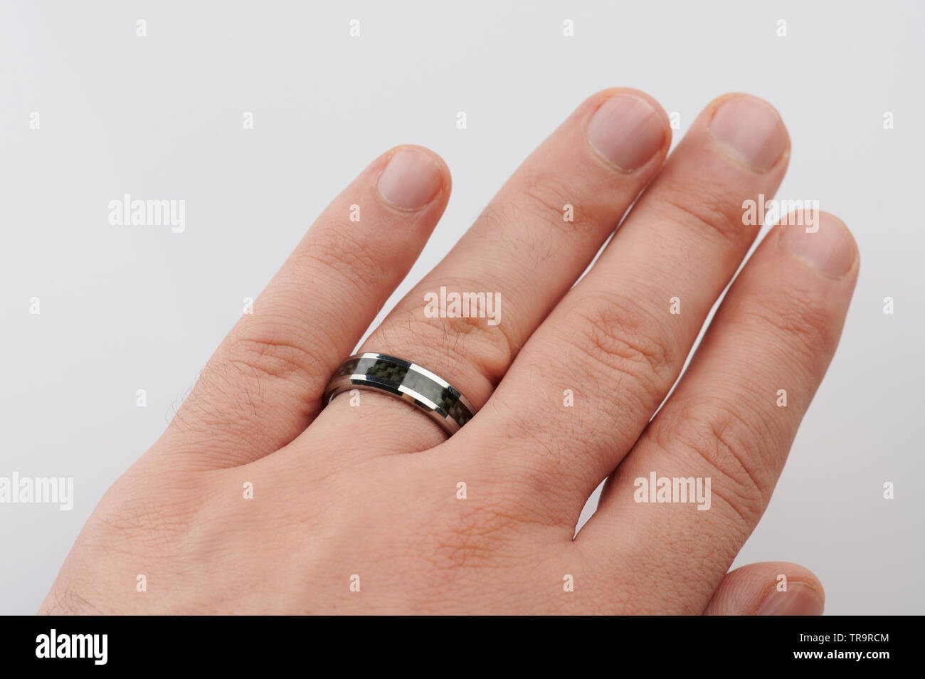 Anello nero sul dito uomo vista ravvicinata isolato Foto Stock