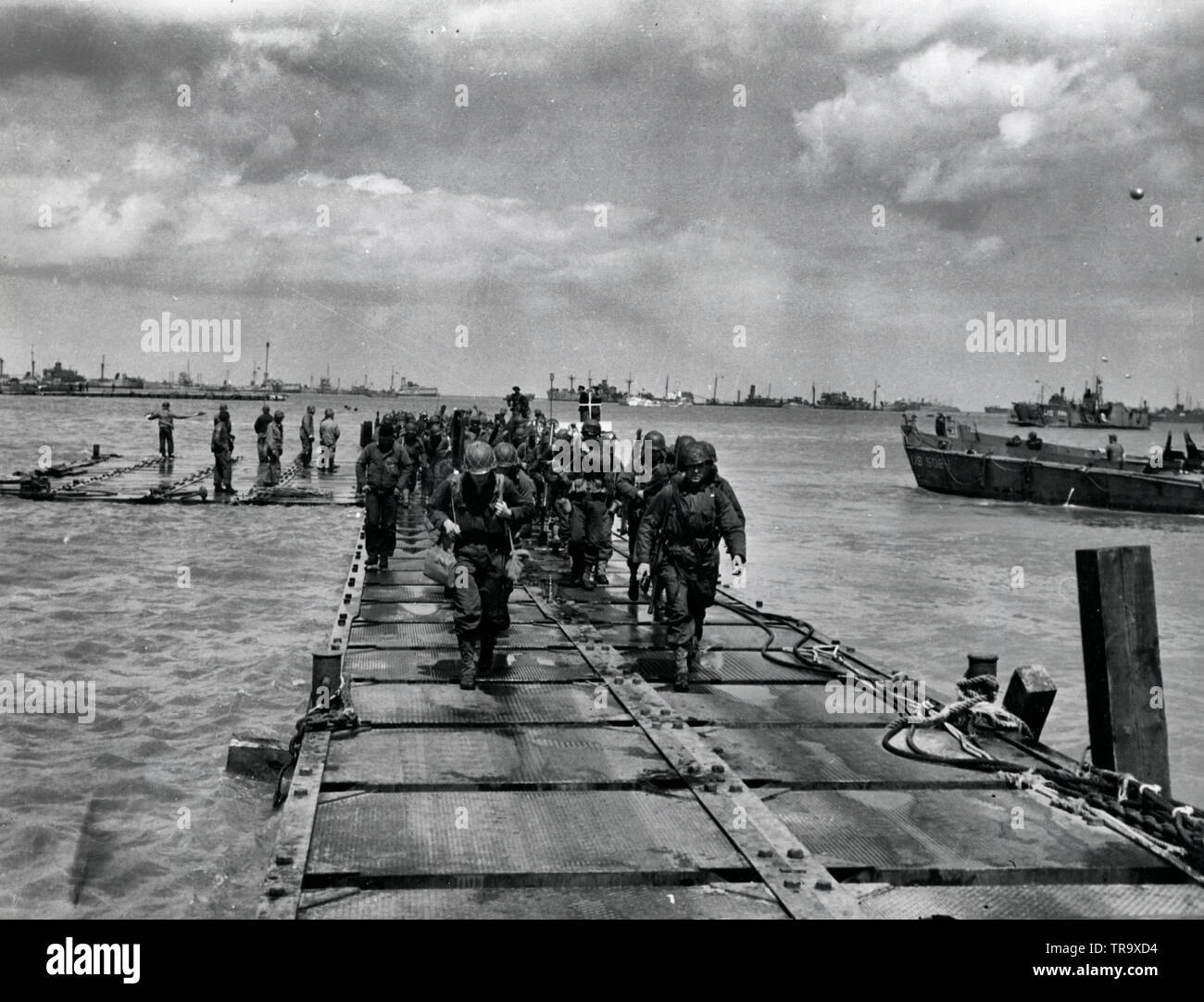 I soldati sbarcano su un pontone causeway costruito dal SeaBees. Questo causeway è stato fissato a Omaha Beach durante lo sbarco in Normandia. Foto Stock