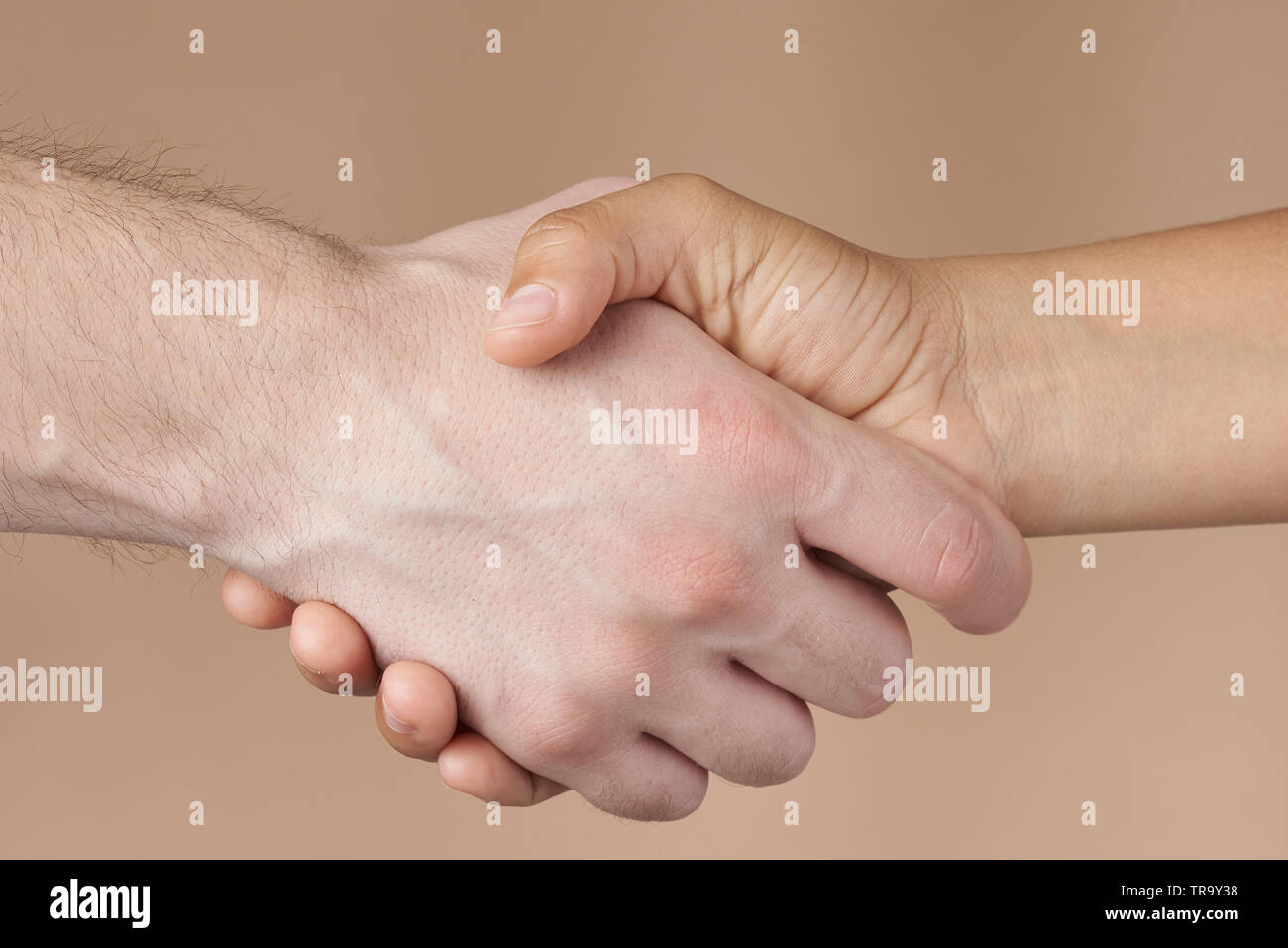 Uomo e donna isolato di handshake su sfondo marrone Foto Stock