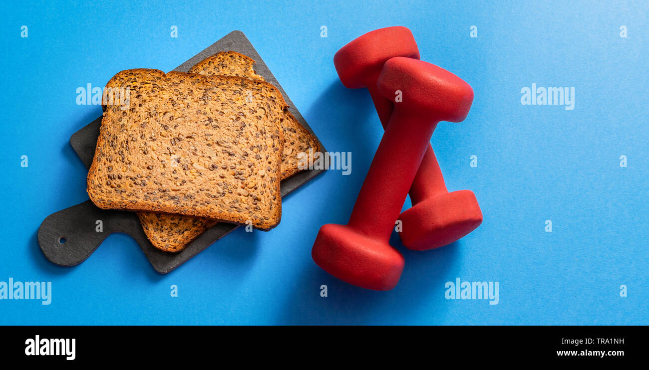 Tutta la proteina di grano low carb pane con manubri, vista dall'alto, copia dello spazio. Pane Fitness concetto. Foto Stock