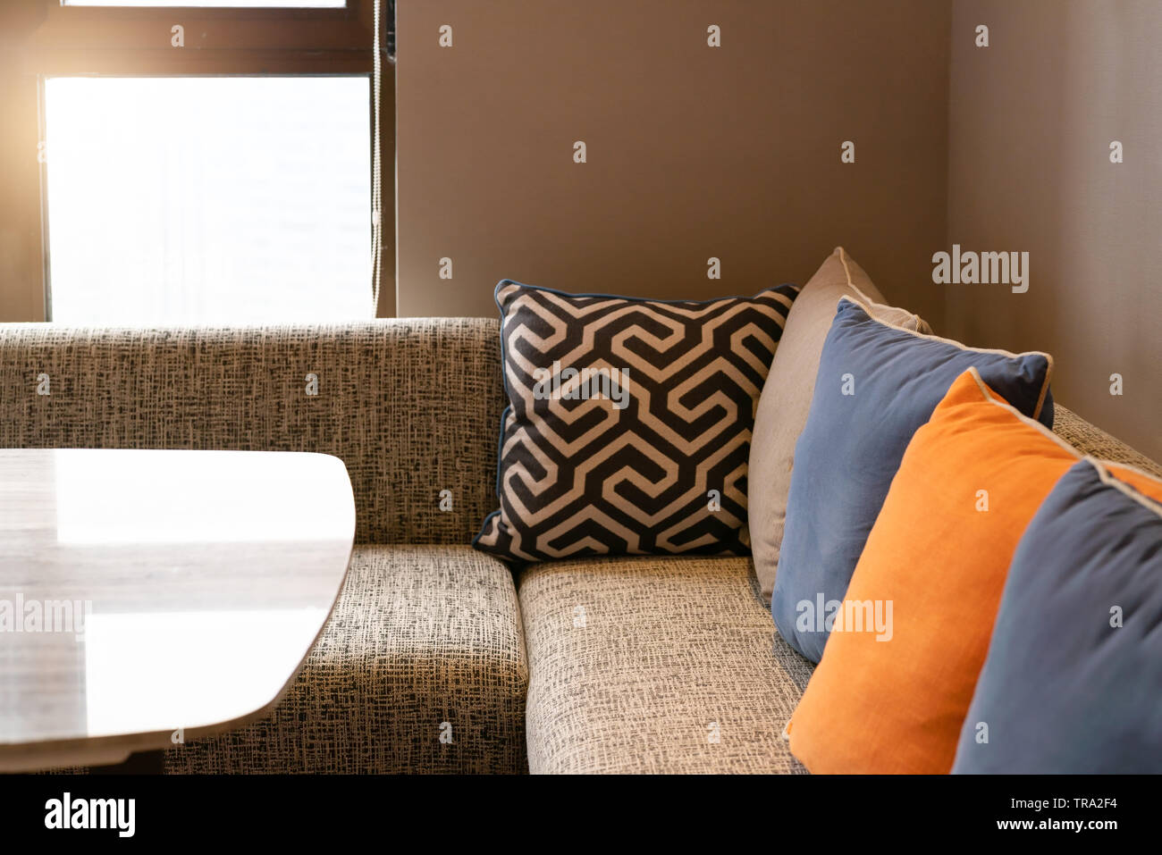 Home design interno, comodo divano in soggiorno con cuscini colorati. Foto Stock