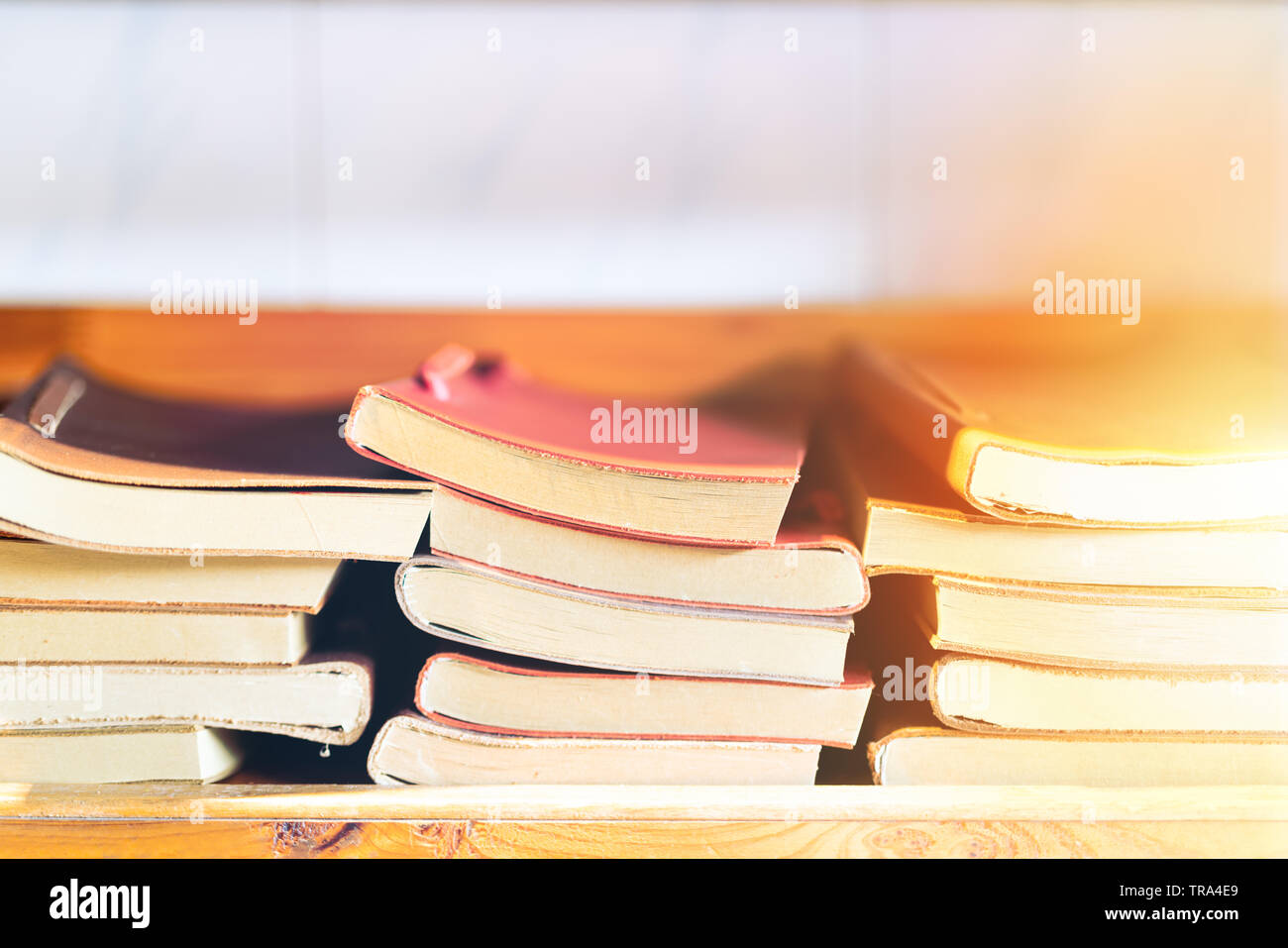 pila di libri su una mensola di legno, libro colorato della copertura di pelle Foto Stock