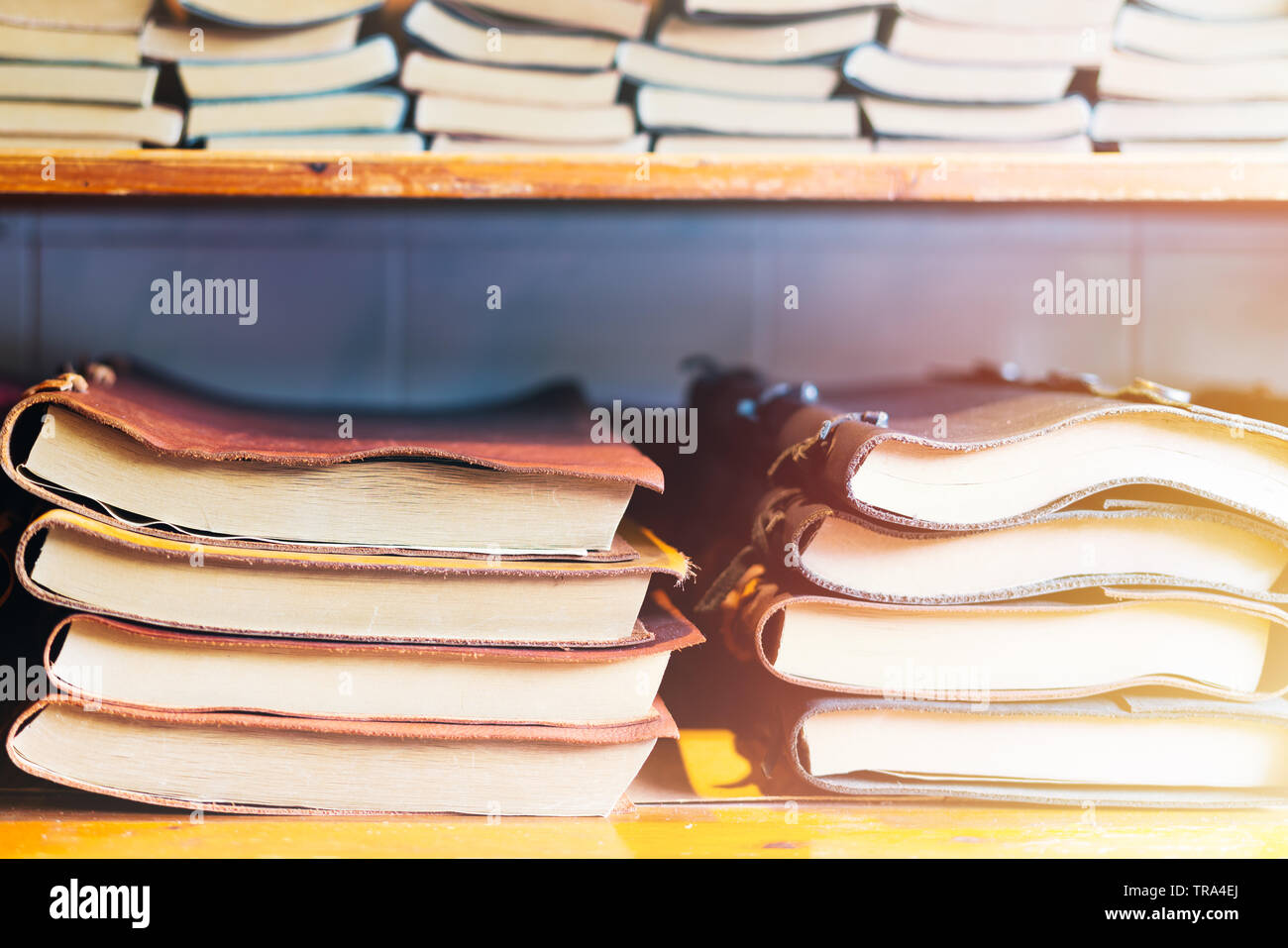 pila di libri su una mensola di legno, libro colorato della copertura di pelle Foto Stock