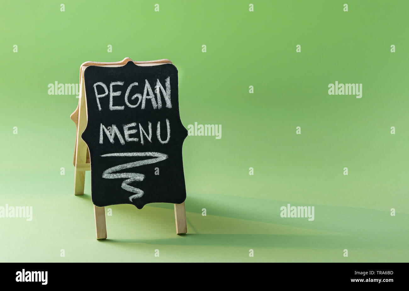 Lavagna con il testo "Menu Pegan' su sfondo verde con copia spazio. Paleo plus concetto vegan. Pegan dieta. Foto Stock