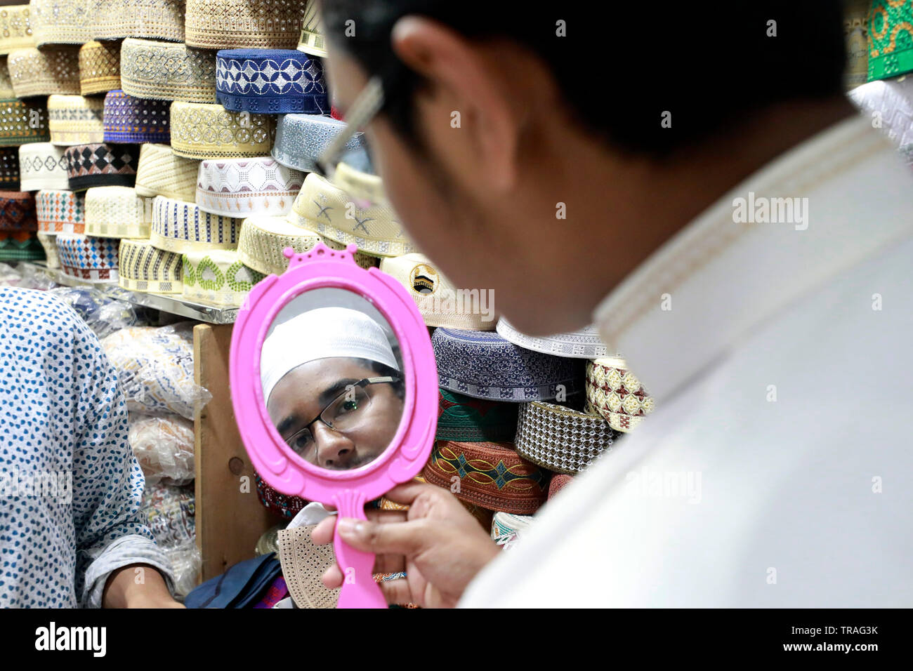 Dacca in Bangladesh - Giugno 01, 2019: Un cliente cerca un tupi o cappuccio di preghiera presso un negozio al Baitul Mukarram Moschea Nazionale precedendo sul mercato dell'Eid-ul- Foto Stock