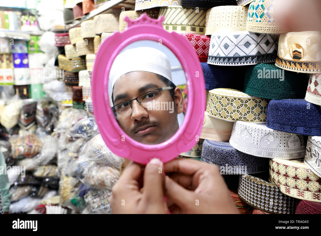Dacca in Bangladesh - Giugno 01, 2019: Un cliente cerca un tupi o cappuccio di preghiera presso un negozio al Baitul Mukarram Moschea Nazionale precedendo sul mercato dell'Eid-ul- Foto Stock