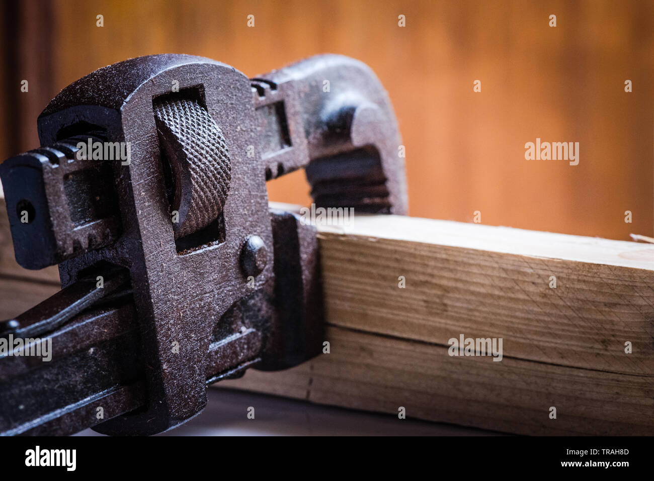 Conept colpo di colorate chiave a tubo strumento mano calmped un pezzo di legno in background isolato Foto Stock