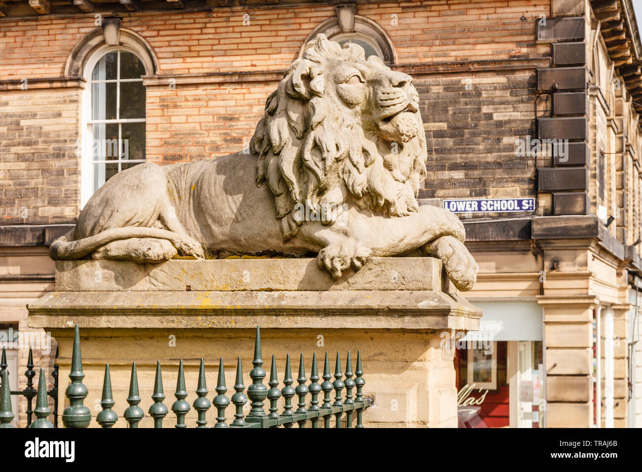 La vigilanza, uno dei due sculture di Lion al di fuori della scuola di fabbrica in Saltaire, Bradford, West Yorkshire Foto Stock