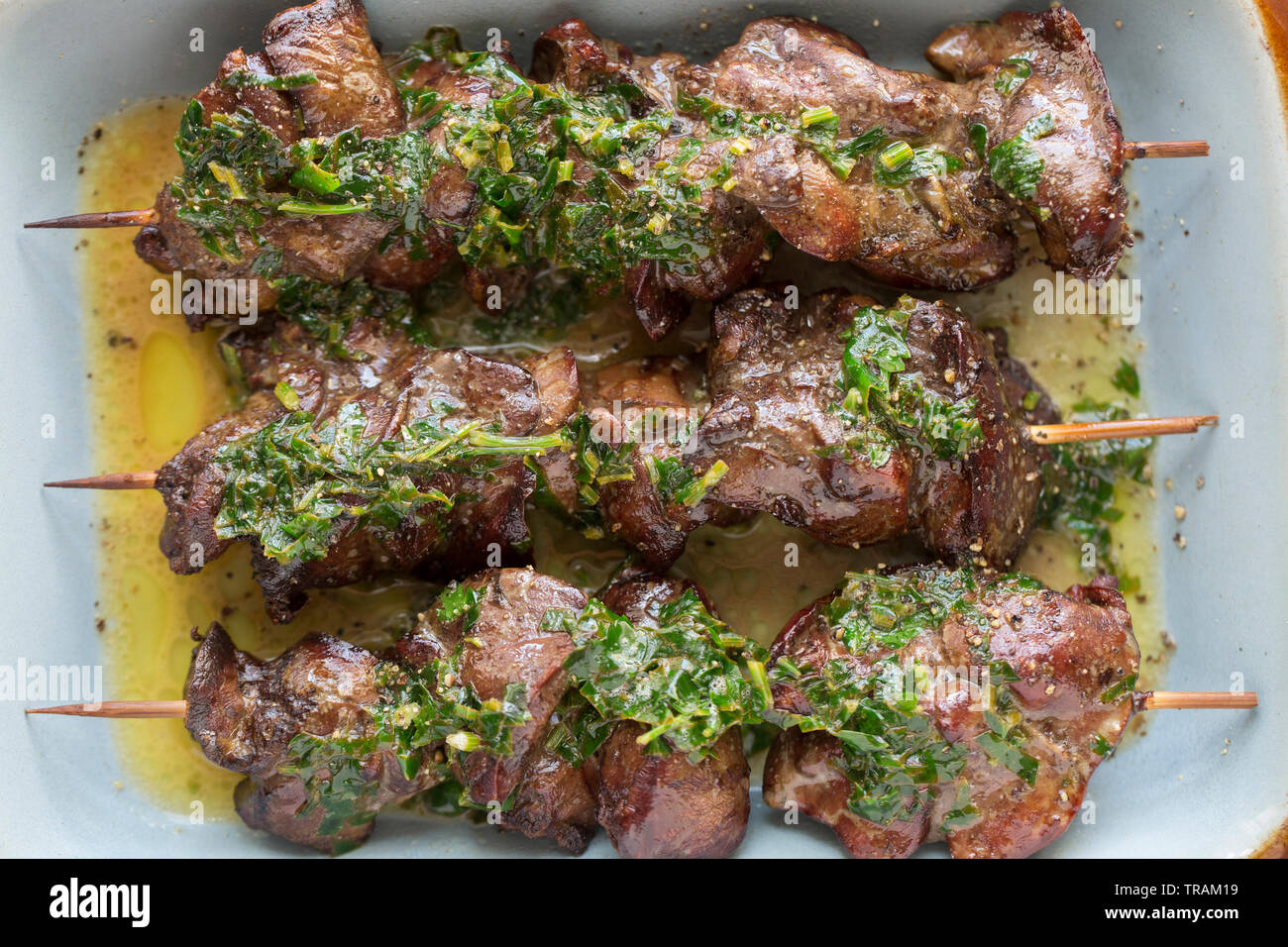 Cuocere i fegatini di pollo che erano a prezzo ridotto dopo aver raggiunto la loro data di scadenza e comprato da un supermercato nel Regno Unito. Essi sono stati infilzato su Foto Stock
