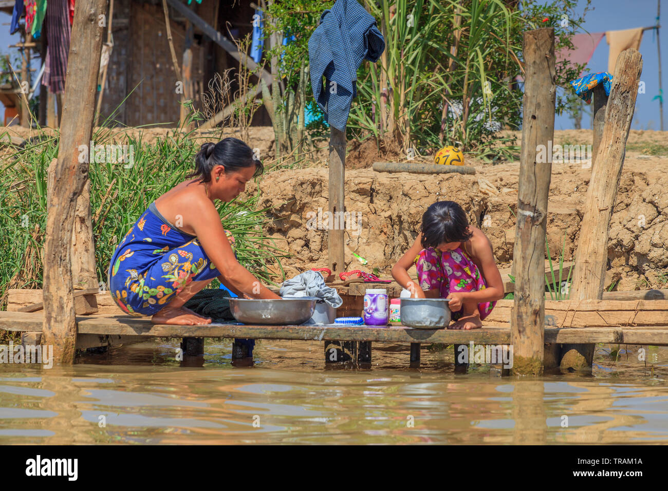 Madre e figlia il bucato davanti alla loro casa, Lago Inle Myanmar Foto Stock