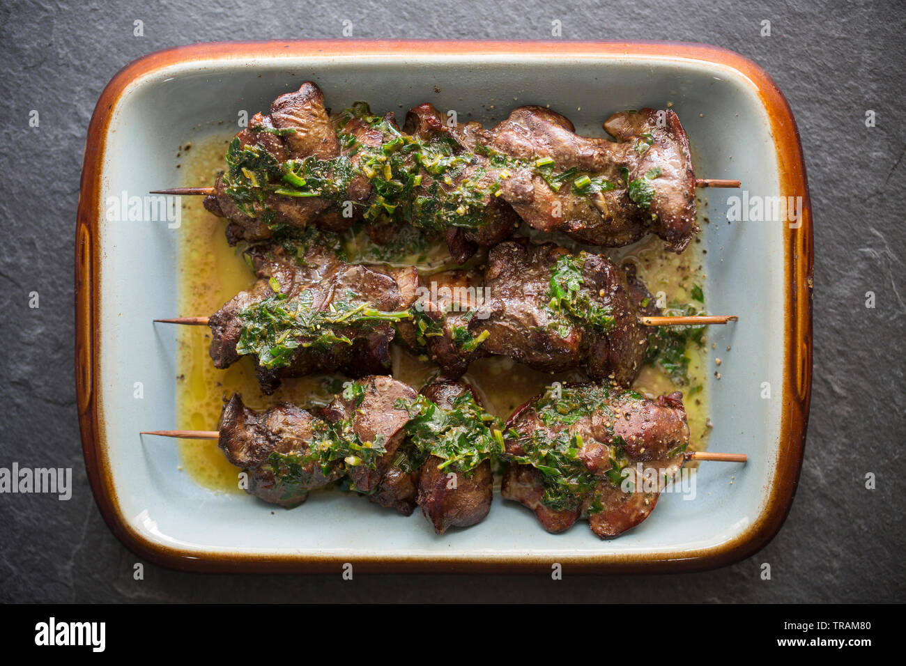 Cuocere i fegatini di pollo che erano a prezzo ridotto dopo aver raggiunto la loro data di scadenza e comprato da un supermercato nel Regno Unito. Essi sono stati infilzato su Foto Stock