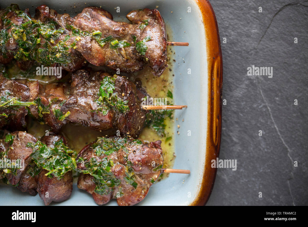 Cuocere i fegatini di pollo che erano a prezzo ridotto dopo aver raggiunto la loro data di scadenza e comprato da un supermercato nel Regno Unito. Essi sono stati infilzato su Foto Stock
