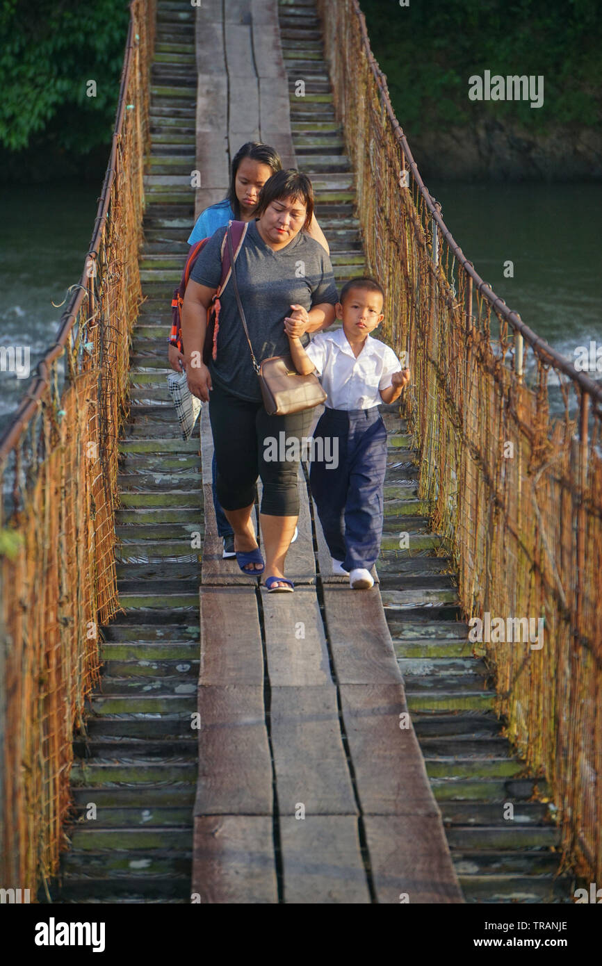 Kiulu Sabah Malaysia - Jan 2, 2019 : Unidentified Madre che accompagna il suo figlio camminando sul ponte di sospensione passerella per frequentare la prima giornata di sessione di scuola. Foto Stock