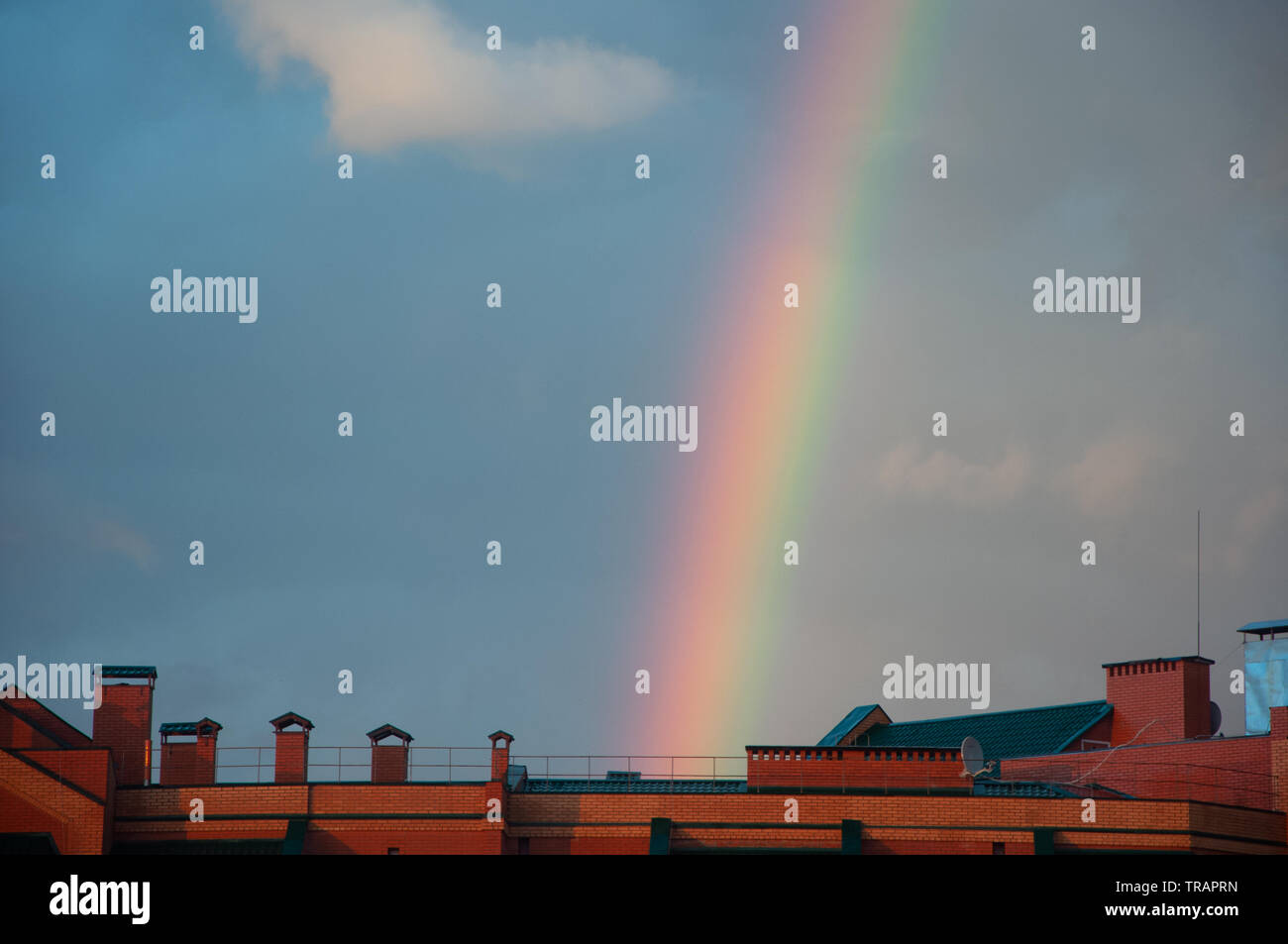 Colorato arcobaleno nel tramonto cielo nuvoloso al di sopra dell'edificio Foto Stock