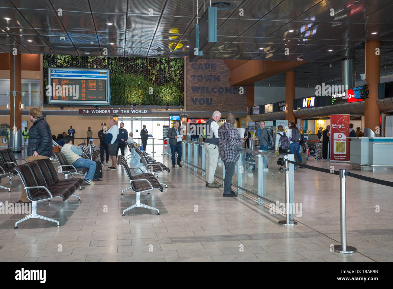 Arrivo internazionale hall in un terminal dell'Aeroporto Internazionale di Città del Capo in Sud Africa con persone in attesa per i passeggeri di arrivare Foto Stock