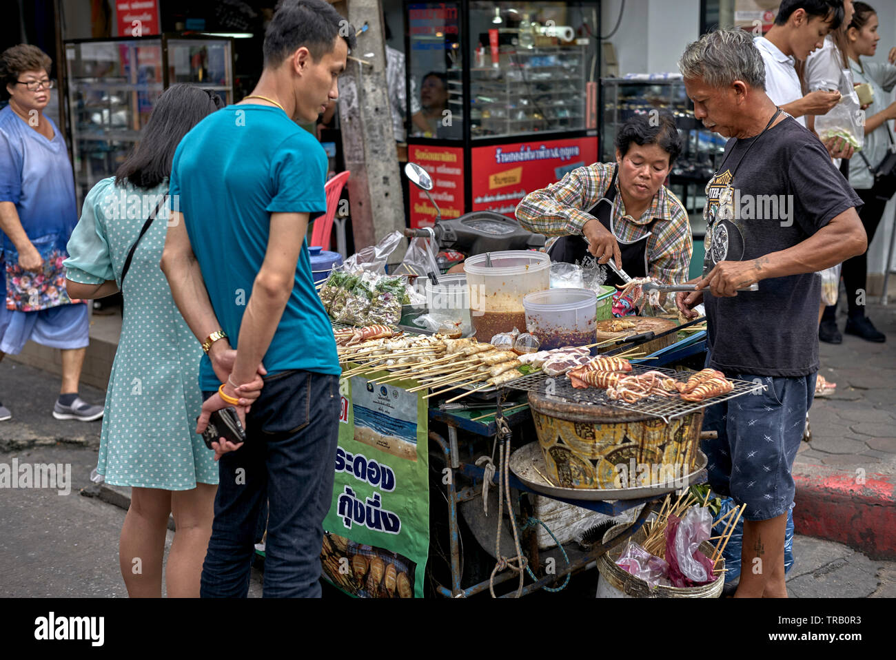 Thailandia street fornitore di cibo che serve i clienti appena cucinata varietà di frutti di mare Foto Stock