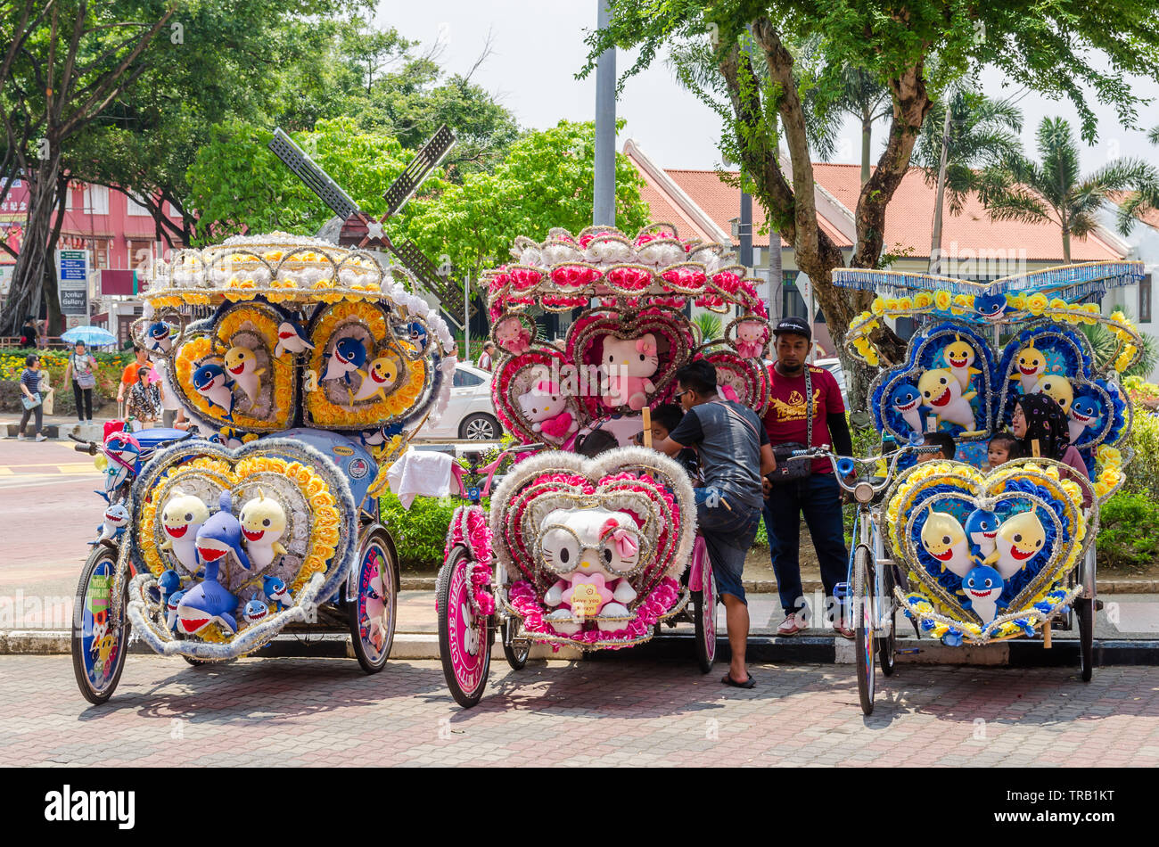 Malacca,Malesia - Aprile 21,2019 : il colorato decorato rickshaws sono il parcheggio in piazza olandese di Malacca in attesa per i clienti. Foto Stock
