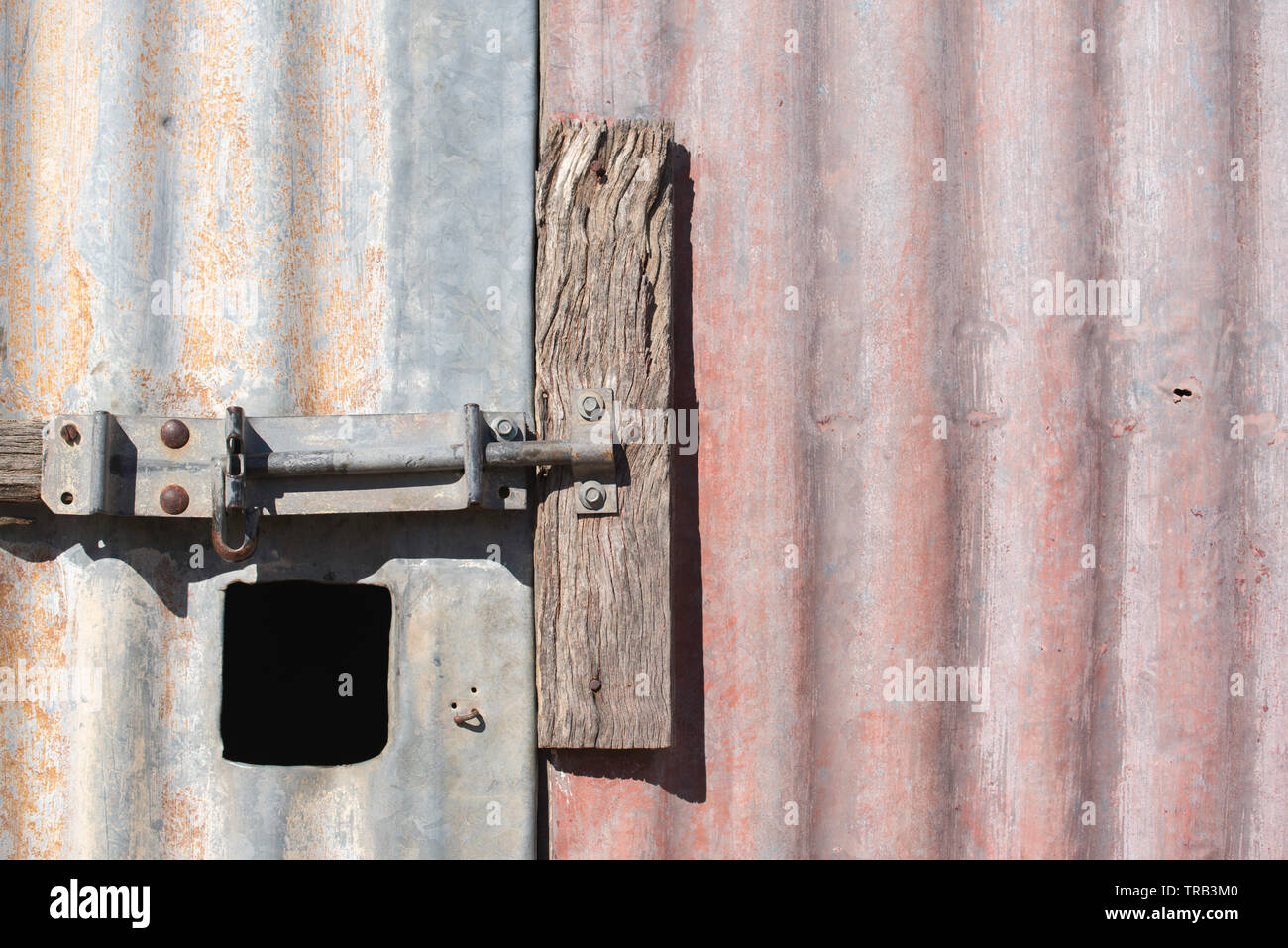 Una chiusura di un bullone scorrevole serratura sulla porta di un vecchio ferro zincato capannone o un fienile in una fattoria nel nord-ovest del Nuovo Galles del Sud, Australia Foto Stock