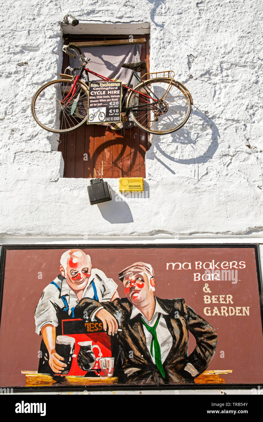 Irlanda, Co Louth, Carlingford, vecchia banchina Lane, noleggio bici Bicicletta sospesa sopra ma Baker's Bar pubblicità segno Foto Stock