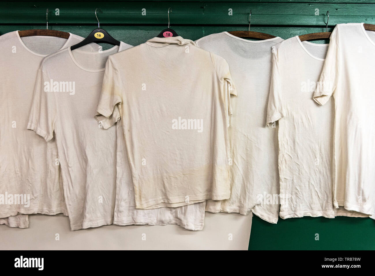 Vecchio usurato white T shirt su appendiabiti. Foto Stock