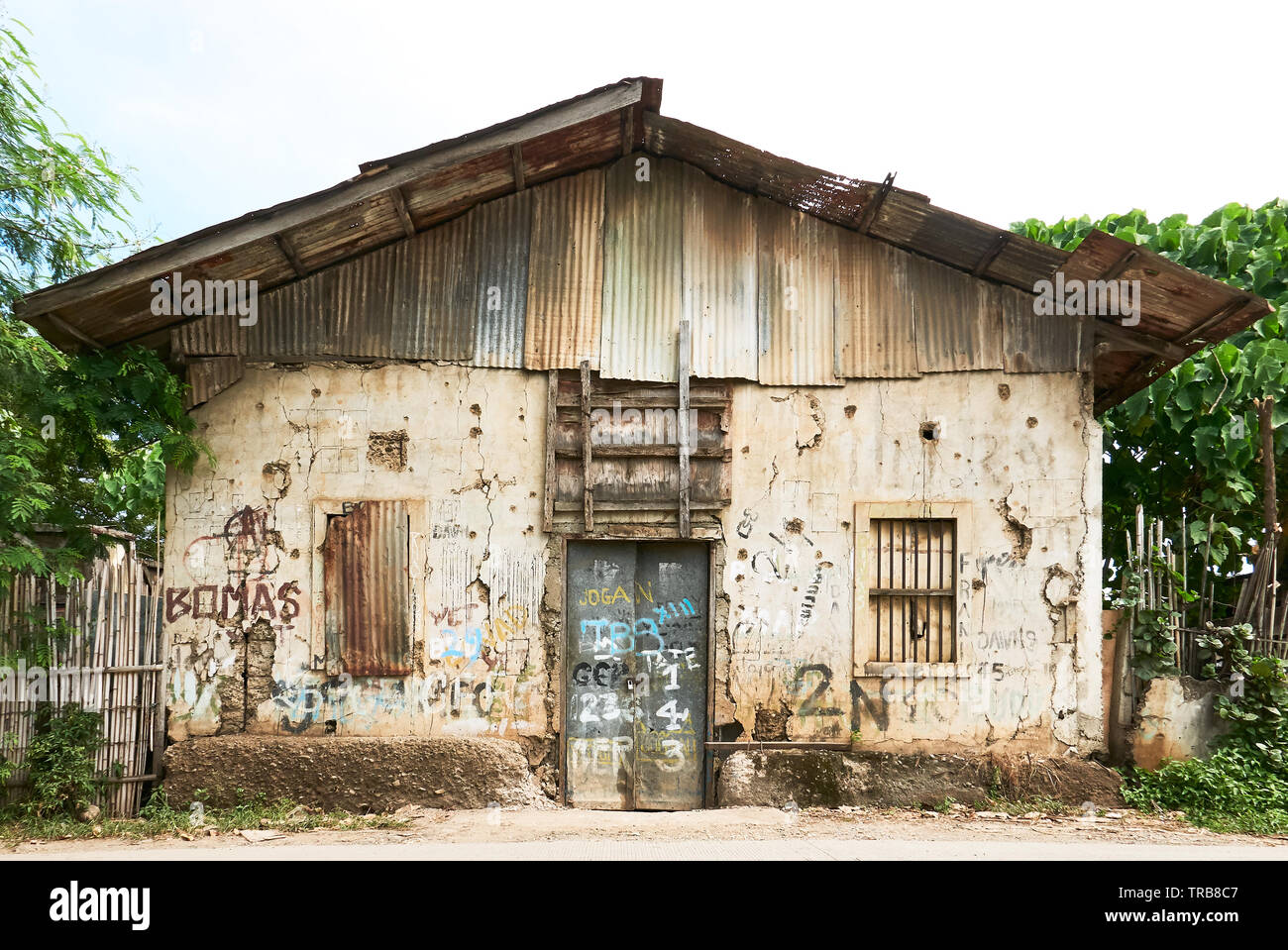 Puerto Princesa City, PALAWAN FILIPPINE: Vista ravvicinata del frontale di un abbandonato edificio rovinato con le finestre chiuse e la porta Foto Stock