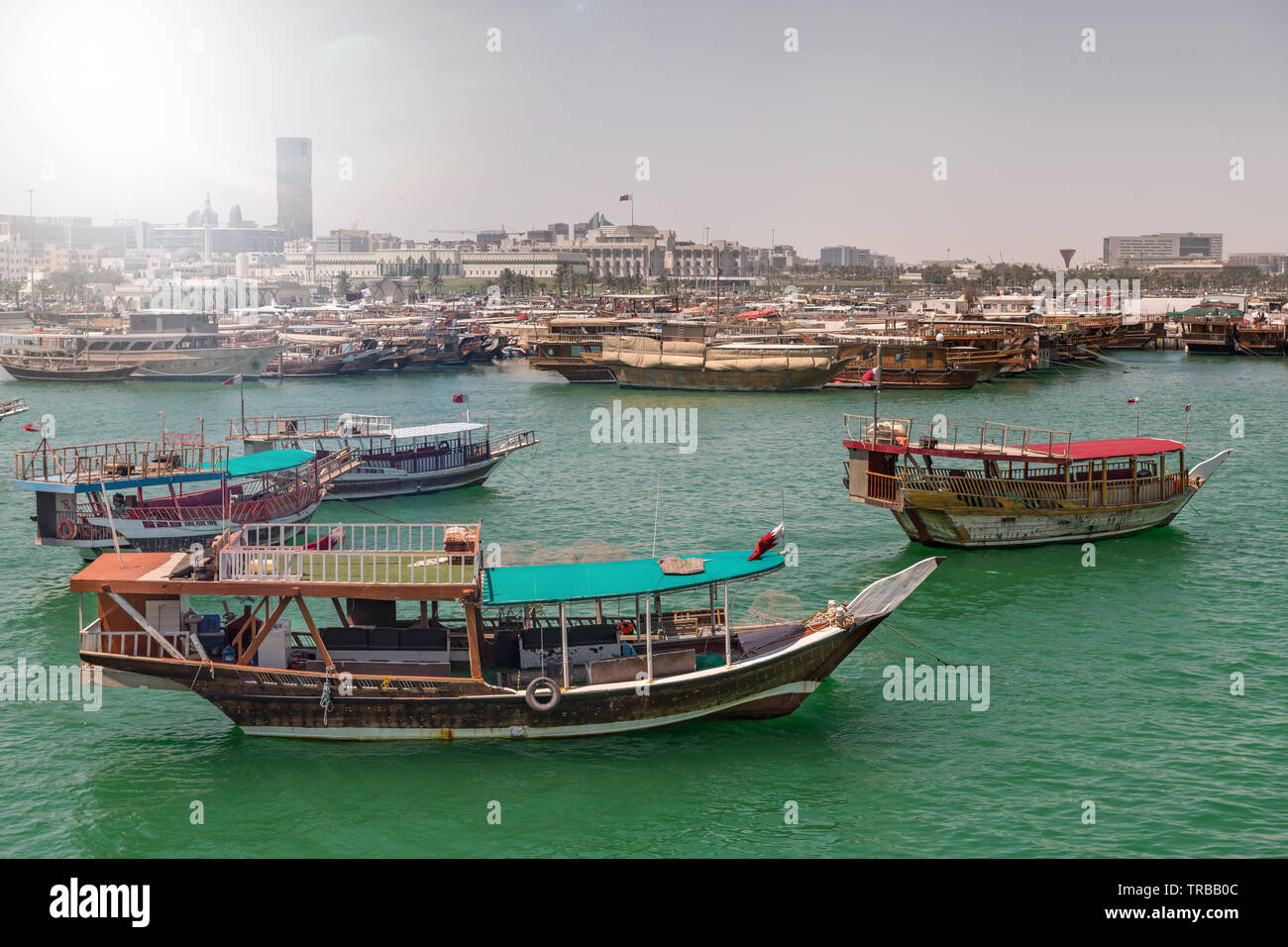 Vecchie navi tradizionali nell'acqua. La città di Doha in background. Foto Stock