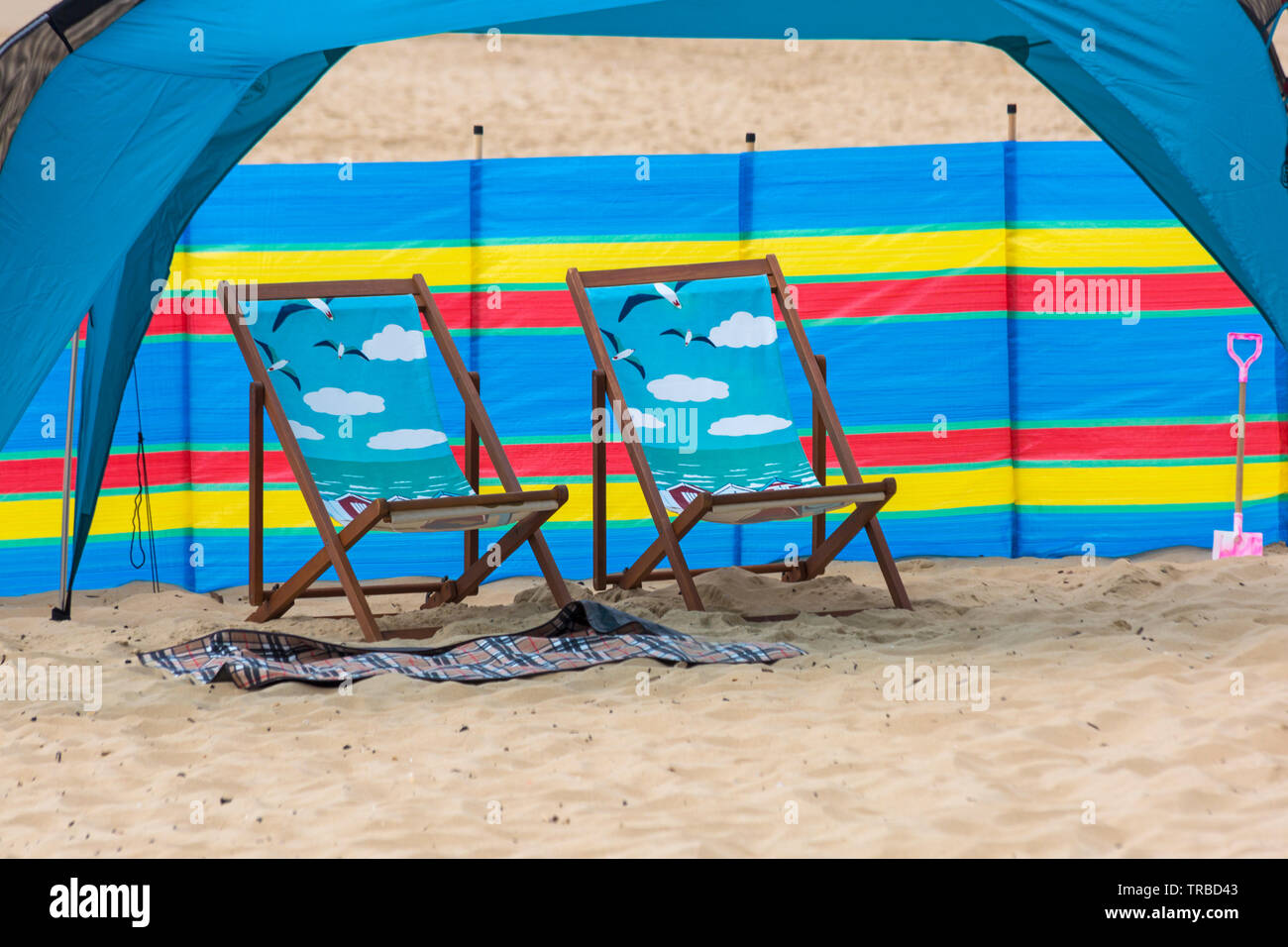 Sedie a sdraio decorative di fronte al vento break frangiflutti a Bournemouth Beach, Dorset UK nel mese di giugno Foto Stock