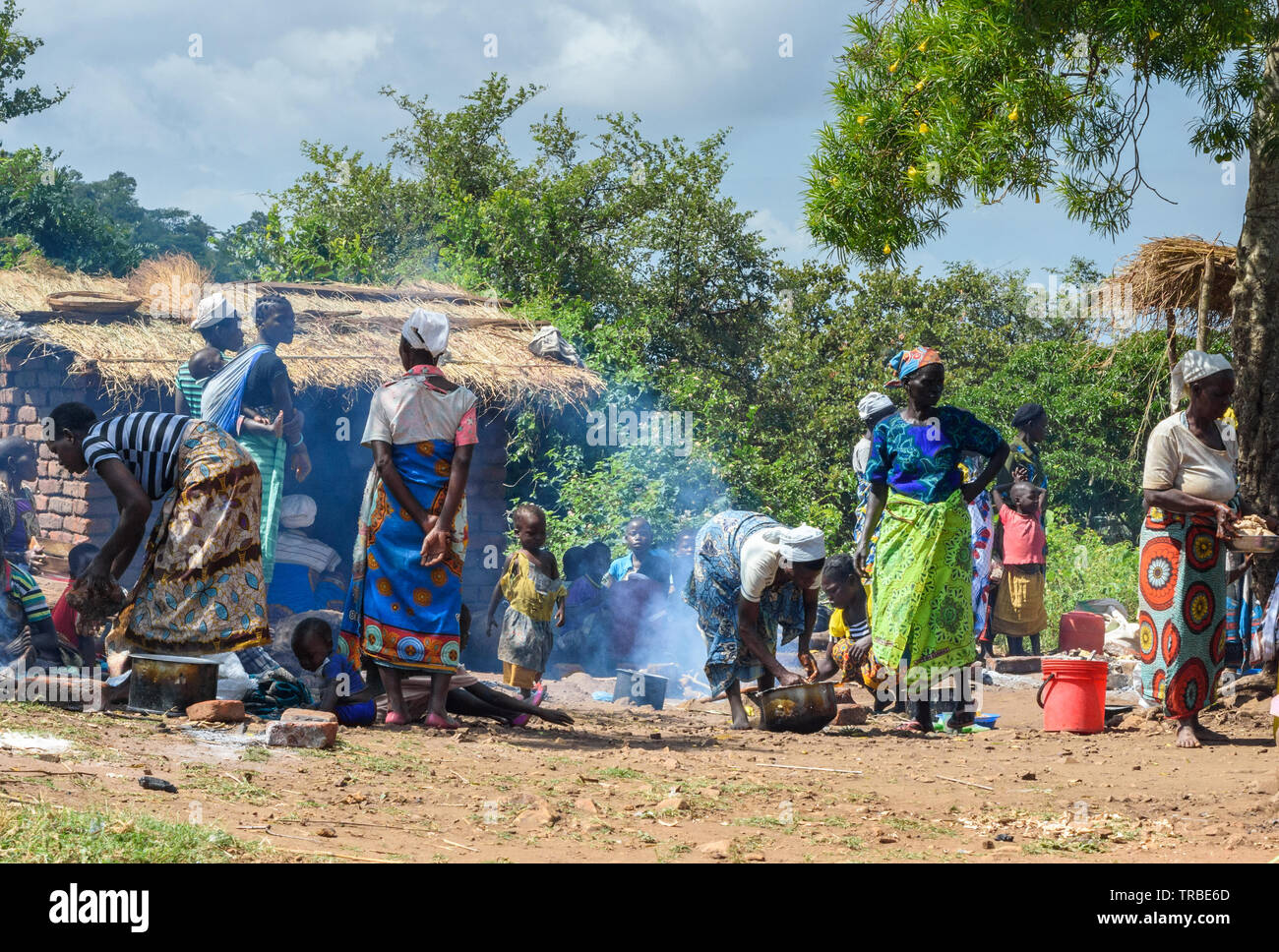 Donne nsima cottura o polenta su fuochi aperti in un villaggio del Malawi Foto Stock