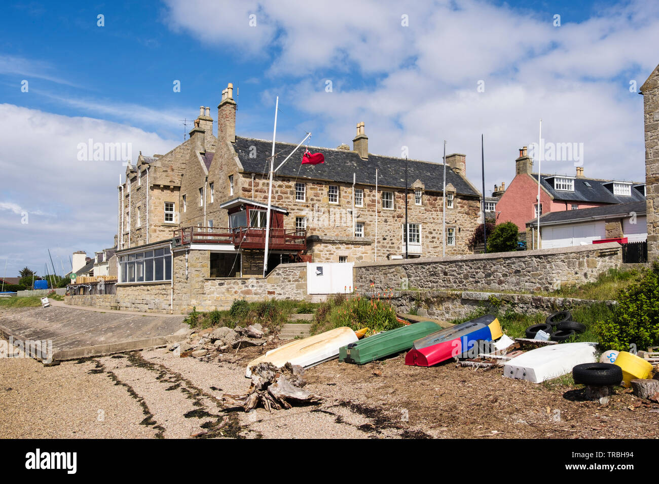 Barche capovolta sulla riva del mare da Findhorn casa costruita nel 1775 home di Findhorn Royal Yacht Club affacciato sulla Baia di Findhorn. Findhorn, murene, Scozia, Regno Unito, Foto Stock