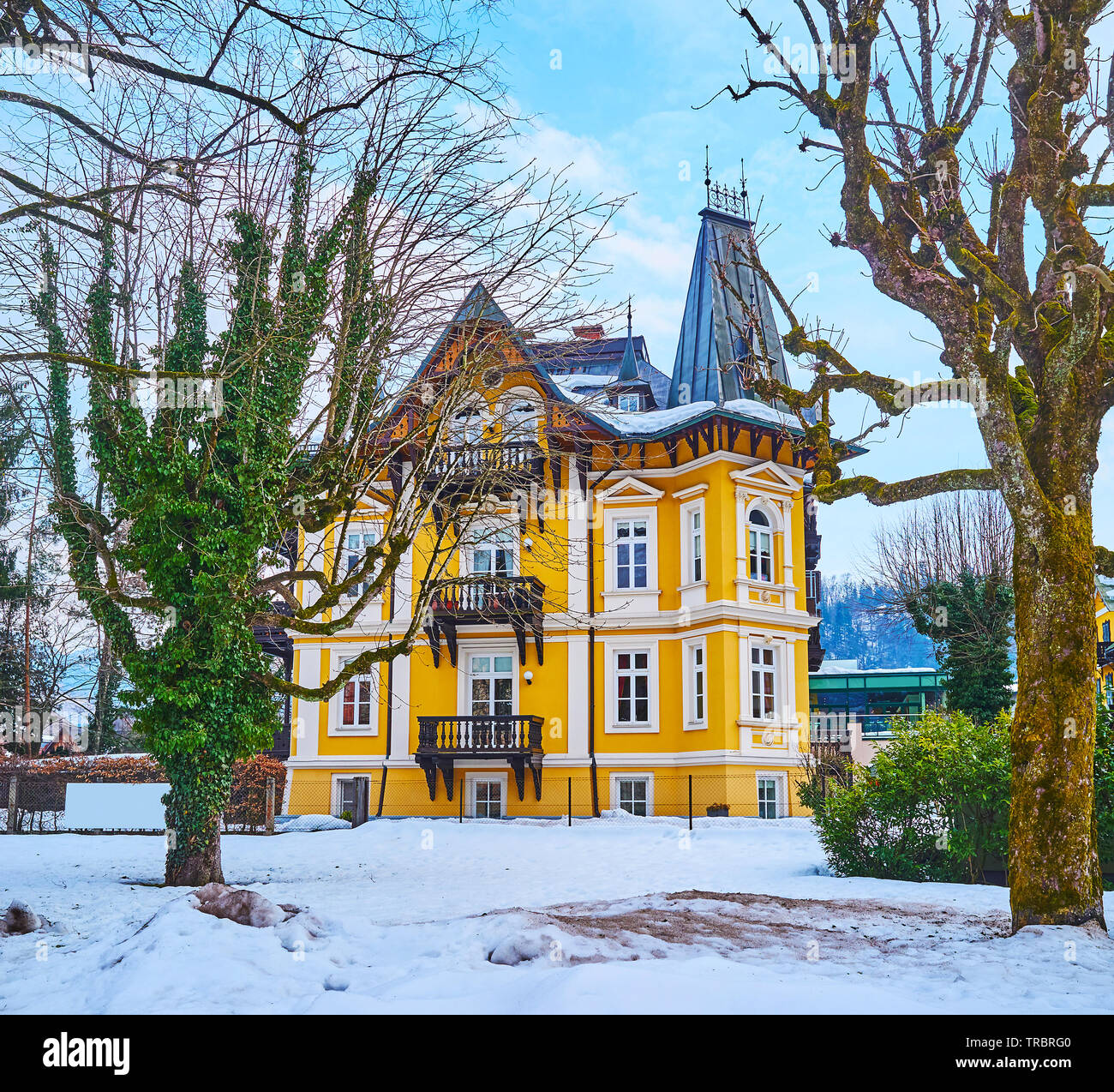 La vista sulla Scenic vintage mansion attraverso gli alberi del giardino d'inverno, situato in Kurhausstrasse, Bad Ischl, Salzkammergut, Austria Foto Stock