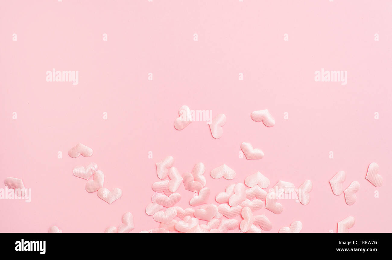 Gli elementi in forma di cuore battenti su sfondo rosa. i simboli di amore felice per donna, madre, il giorno di San Valentino Foto Stock