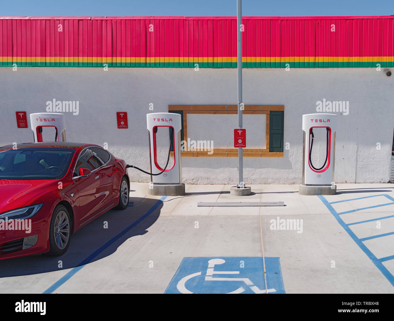 Stazione di ricarica Tesla e ricarica auto mostrate nel deserto del Mojave. Foto Stock