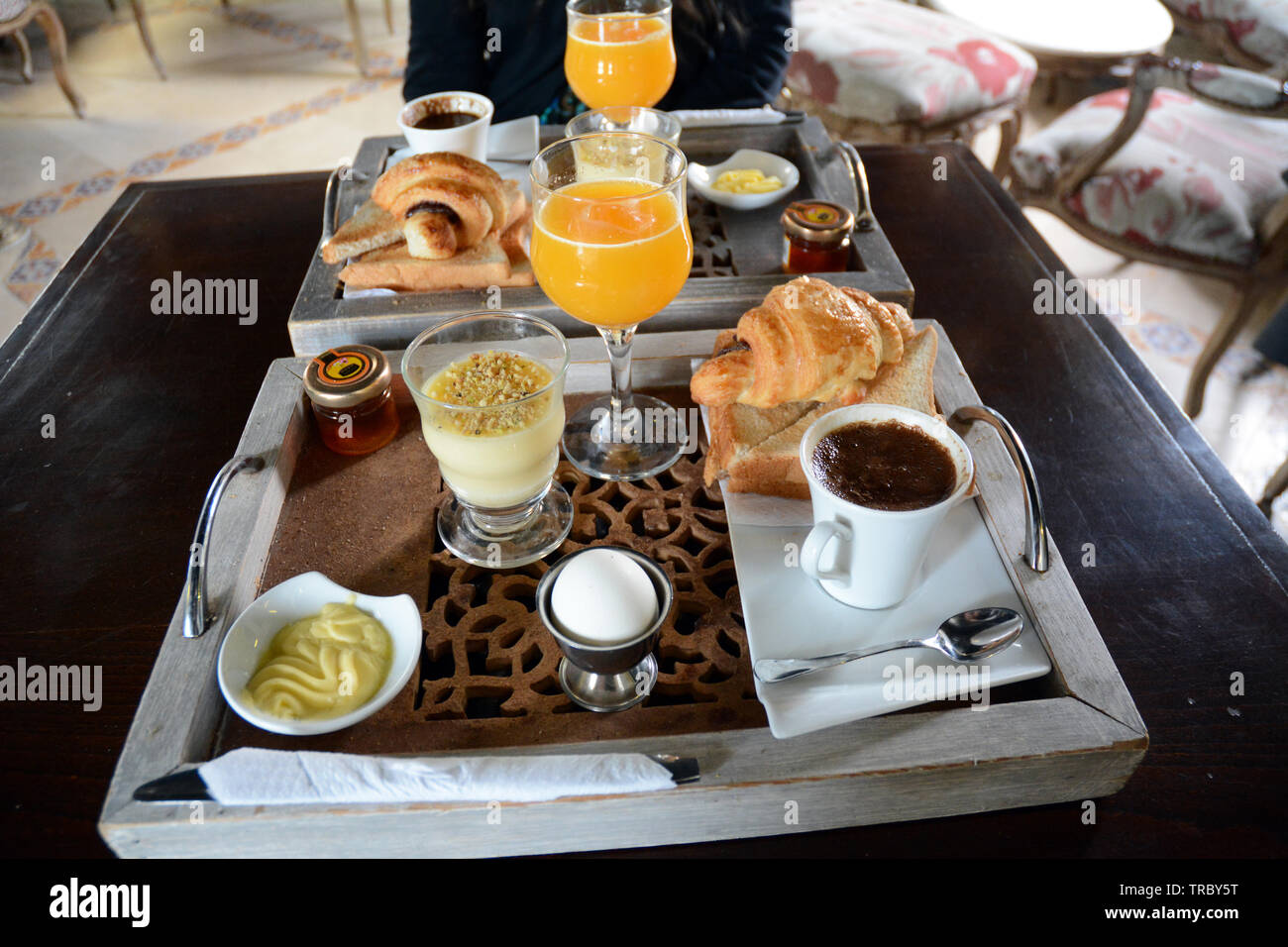 Continentale colazione tunisino di caffè, succo d'arancia, croissant, crema pasticcera, un uovo, toast, marmellata e burro a cafe nella medina di Tunisi, Tunisia. Foto Stock