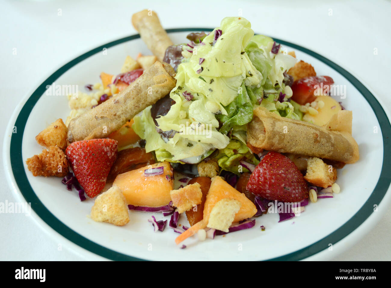 Un cuoco con insalata di frutta e sigari marocchini è servita a Fondouk el Attarine, un bel ristorante nel cuore della medina di Tunisi, Tunisia. Foto Stock