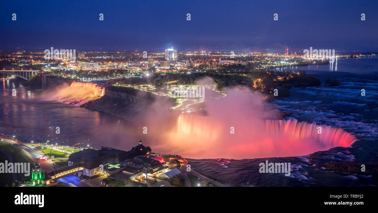 Colorfull luci illumina l'acqua cade sulle Cascate del Niagara in serata. Foto Stock