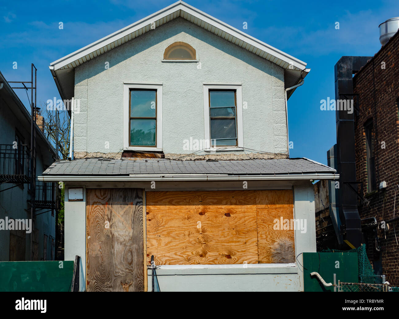 Vecchia casa con ingresso e finestre al primo piano affissi dalle lenzuola di legno. Foto Stock