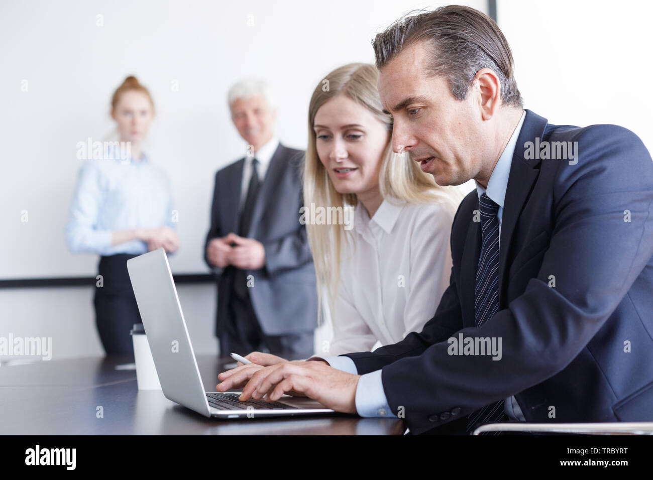 La gente di affari a lavorare con il computer portatile insieme in ufficio Foto Stock