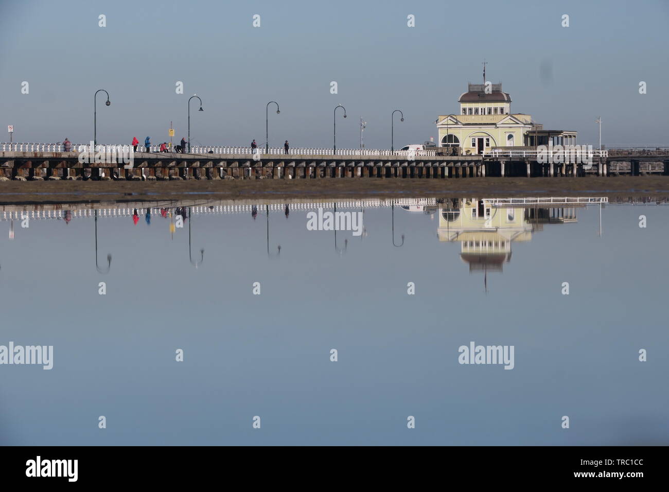 Melbourne Australia. St Kilda Pier su un perfettamente calma giorno riflette nei fondali bassi. Foto Stock