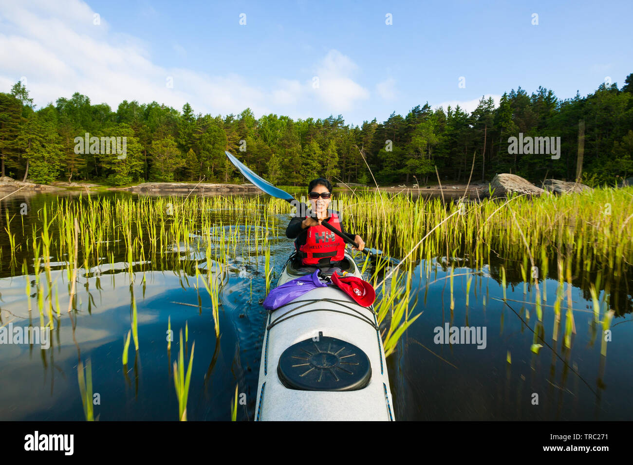 Fotografo Outdoor Zizza Gordon paddling in un kayak nel lago Vansjø, Østfold, Norvegia. Il lago Vansjø è il lago più grande in Østfold. Vansjø e i suoi dintorni di laghi e fiumi sono una parte dell'acqua sistema chiamato Morsavassdraget. Giugno, 2010. Foto Stock