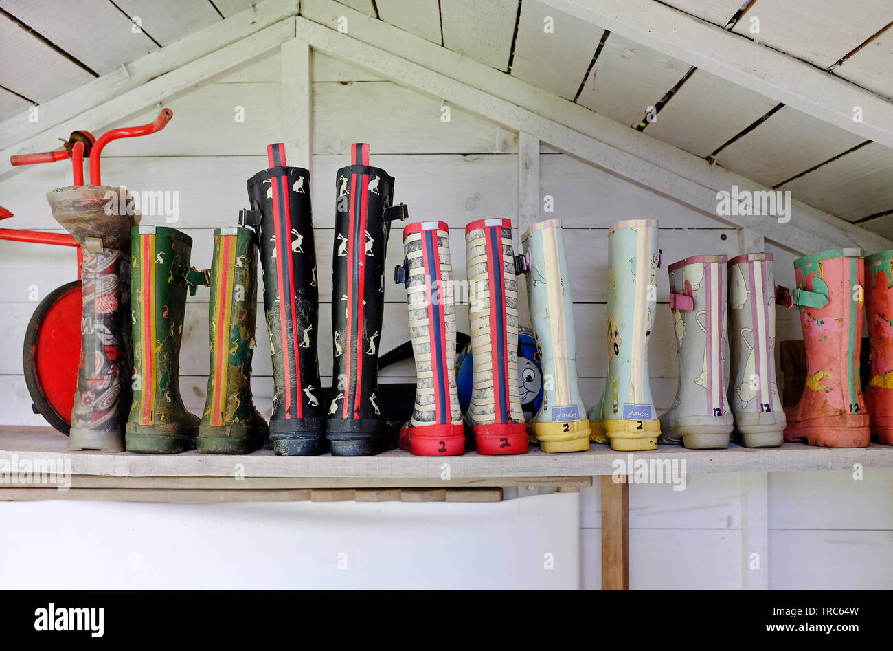 Bambini stivali di gomma sul ripiano in casa estiva, North Norfolk, Inghilterra Foto Stock