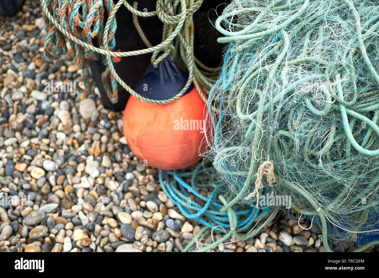 Green plastica nylon reti da pesca e la corda su una spiaggia Foto Stock